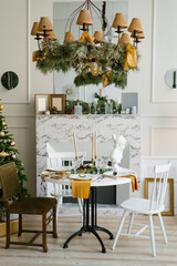 Stylish Scandinavian interior of the dining room with a Christmas tree. Various chairs near the round table. Classic modern home