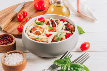Italian pasta with chicken meatballs, tomatoes and basil.
