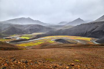 volcanic desert in the middle of the Icelandic landscape, road for off-road vehicles leads through a desolate landscape, rainy weather, Iceland - 389968457