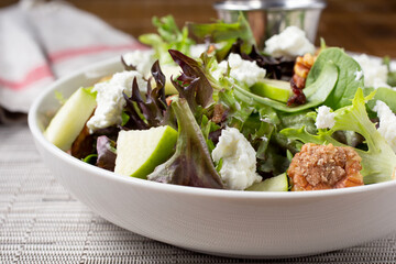 A view of a Mediterranean salad, featuring walnuts, green apples, and feta cheese.