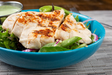 A view of a grilled chicken salad in a bowl.