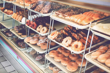 A view of a glass display of donuts at a local donut shop.