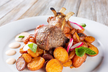 A view of a plate of lamb chops and potatoes.