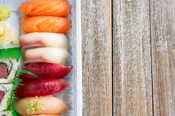 A top down view of a platter of assorted sushi , in a restaurant or kitchen setting.