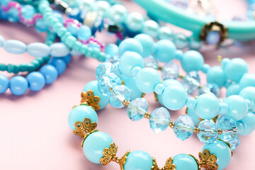 Beautiful blue bracelets on pink background