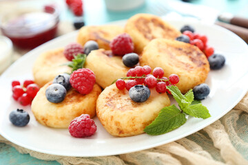 Sweet cheese pancakes with berries and mint leafs