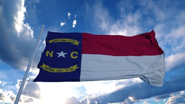 North Carolina flag on a flagpole waving in the wind, blue sky background. 4K