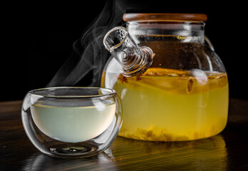 tea pot and Cup of ginger tea with honey and lemon on black background