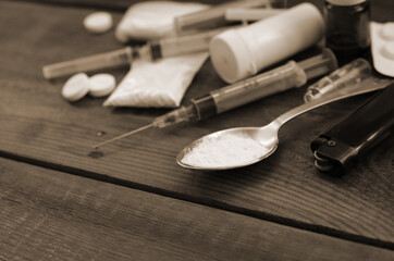 A lot of narcotic substances and devices for the preparation of drugs lie on an old wooden table