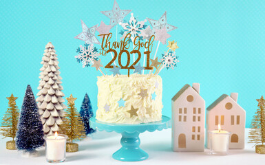 Happy New Year's Eve celebration cake on cake stand in blue white and gold theme decorated with stars and humorous, Thank God It's 2021, cake topper decoration.