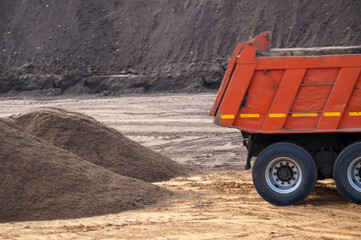 Obraz premium dump truck and a pile of sand at a construction site close up