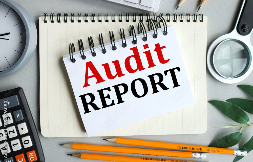 Poster audit report, text on white notepad paper on gray background near calculator