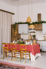 Vintage dining room, decorated for Christmas and New Year. Large dining table with pink tablecloth in the dining room