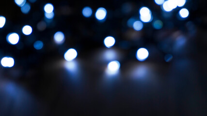 Light effect on a dark background, bright lights, blur, bokeh. Reflection of neon light in water.