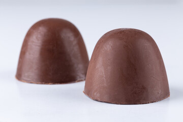 Chocolate truffle with delicious filling isolated on white background. Closeup photography.