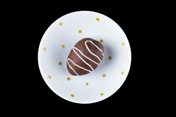 Chocolate truffle with strawberry filling isolated on black background. Closeup photography.