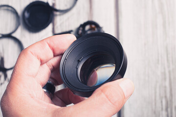 Camera lens unmade and broken with many glasses hanging with a hand a convex lens