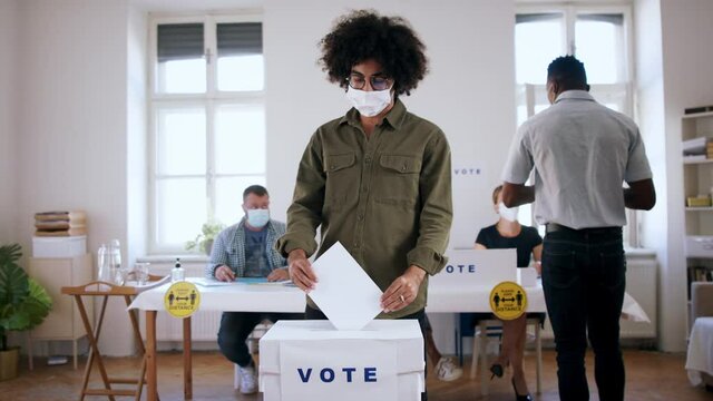 Mature man putting his vote in the ballot box, elections concept.