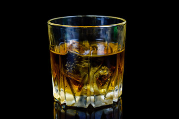 Glass of whiskey isolated on the black background
