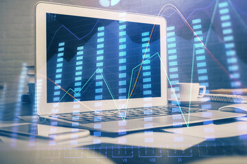 Financial chart drawing and table with computer on background. Double exposure. Concept of...