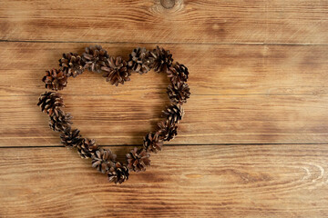 Rustic wood background with pine cones heart.