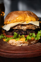 Big hamburger with a glass of beer in the background 