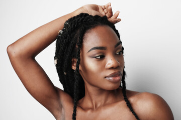 Young African American model with long hair looking aside. Isolated white wall.