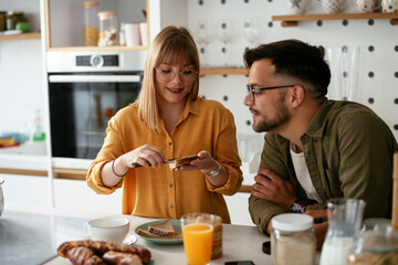 Young couple making sandwich at home. Loving couple enjoying in the kitchen
