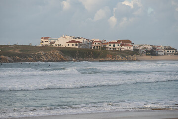 Baleal Island beach and beautiful houses with surfers on the atlantic ocean in Peniche, Portugal