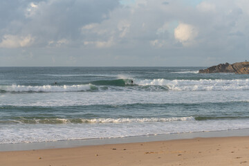 Surfers surfing in Baleal Island beach atlantic ocean waves in Peniche, Portugal