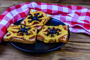 Sandwiches with the spider and spider web on wooden table. Halloween celebration concept
