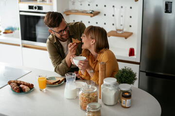 Young couple making sandwich at home. Loving couple enjoying in the kitchen