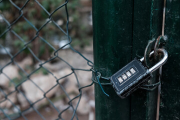 Prison or jail concept, classified. Closed entrance with code padlock on a metal wire fence. Private restricted area with prohibited access. Protected place on lockdown during coronavirus outbreak.