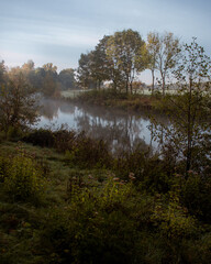 River during sunrise with fields and trees