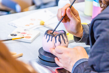 women's hands draw on a ceramic mug