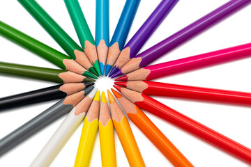 Naklejka premium Colored pencils arranged in a star on white background