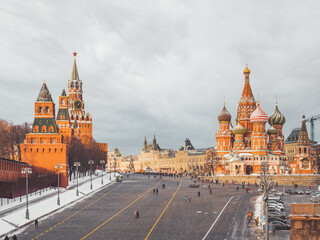 Fototapeta premium Tourists near St. Basil's Cathedral on Red square. Traditional Christmas fair near Kremlin. Moscow, Russia.