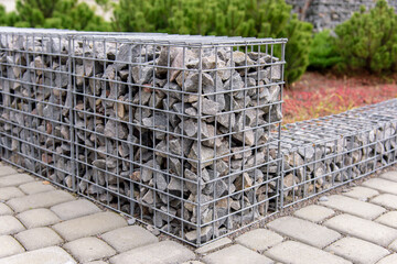 Gabion stone fence. Elements of angular rock and wire mesh gabions.