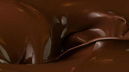 Pouring of delicious dark chocolate, cllose-up.