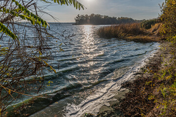 Riverbank, beach on a sunny spring day. Autumn landscape by the river.