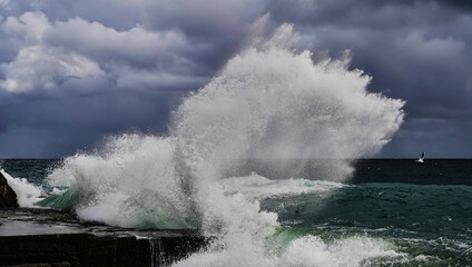Fototapeta na wymiar Stormy weather at sea. Strong waves hitting stones. Strong explosions from the waves of the sea.