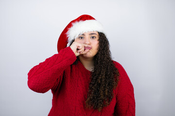 Young beautiful woman wearing a Santa hat over white background mouth and lips shut as zip with fingers. Secret and silent, taboo talking