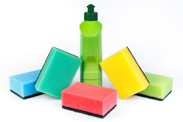 Bottle of dishwashing detergent and colorful sponges on white background.
