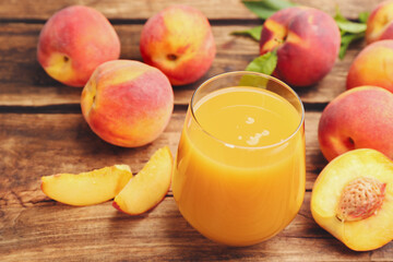 Natural peach juice and fresh fruits on wooden table