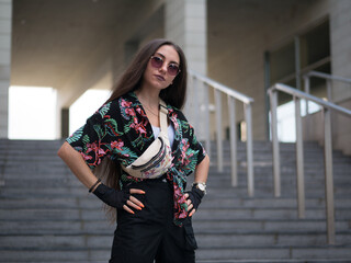 Young attractive sport woman in sportswear with sunglasses posing outdoors.