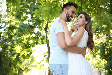 Fototapeta premium Lovely young couple dancing together in park on sunny day