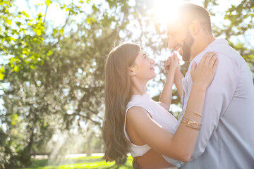 Fototapeta premium Lovely young couple dancing together in park on sunny day