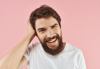 Portrait of a man with a beard and mustache on a pink background close-up cropped view