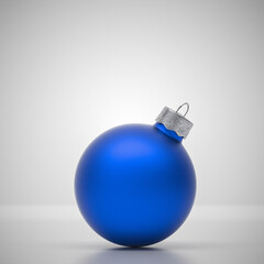 Light blue round matt Christmas ball. Christmas ornament standing on blue background.
