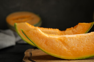 Slices of tasty fresh melon on wooden board, closeup